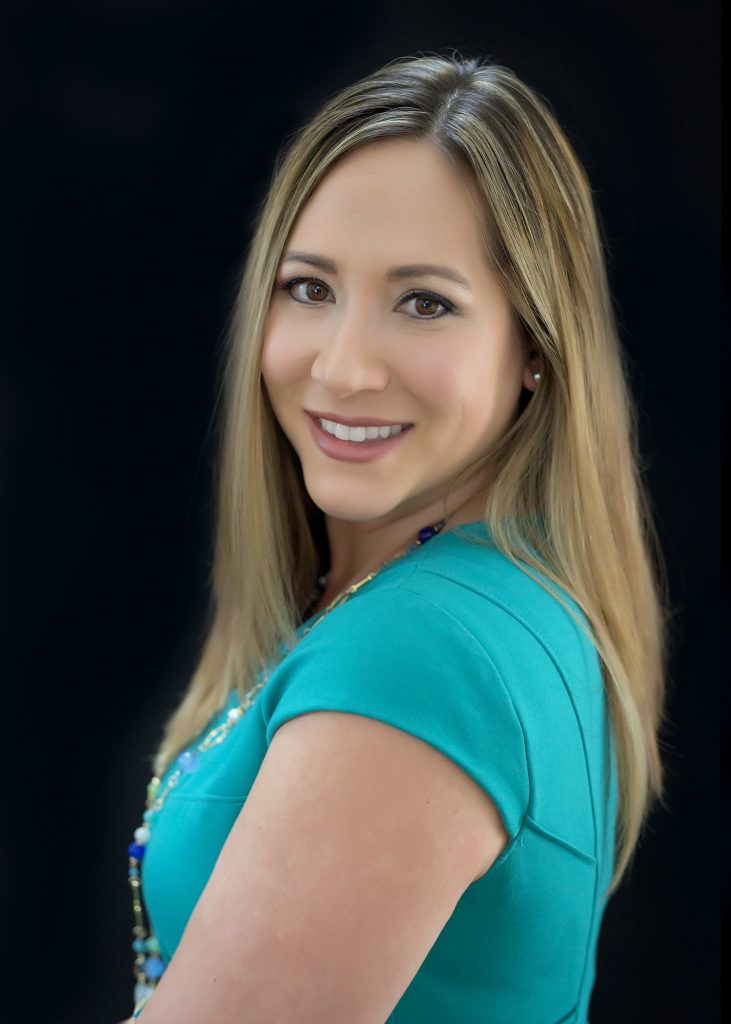 headshot of a woman smiling,  wearing a teal shirt