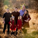 Fall portrait of a family in a field with lots of fall colors