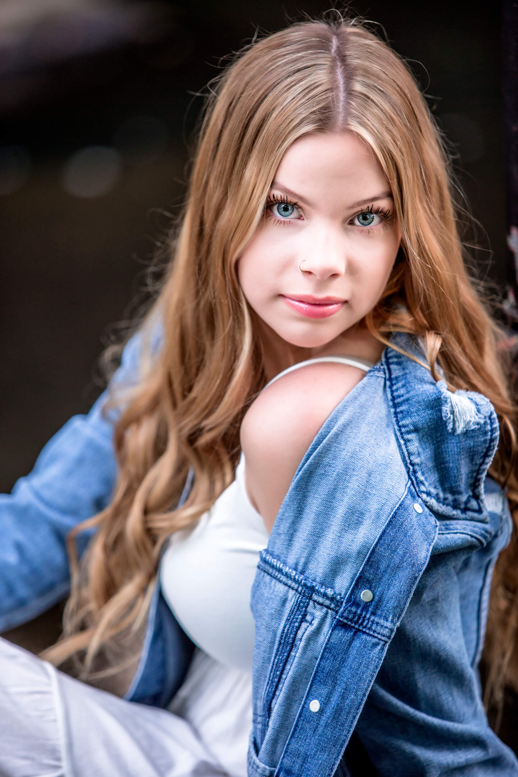 HS Senior girl wearing a white dress jean jacket posing for a Massachusetts senior photographer