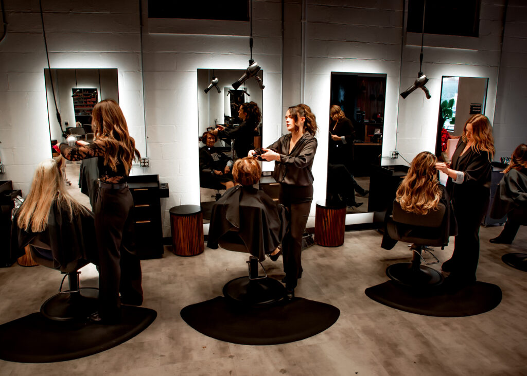 three salon stylists working on clients hair in a luxury salon in massachusetts