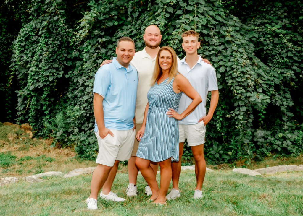 Smiling family of four embracing outdoors, Massachusetts family photography