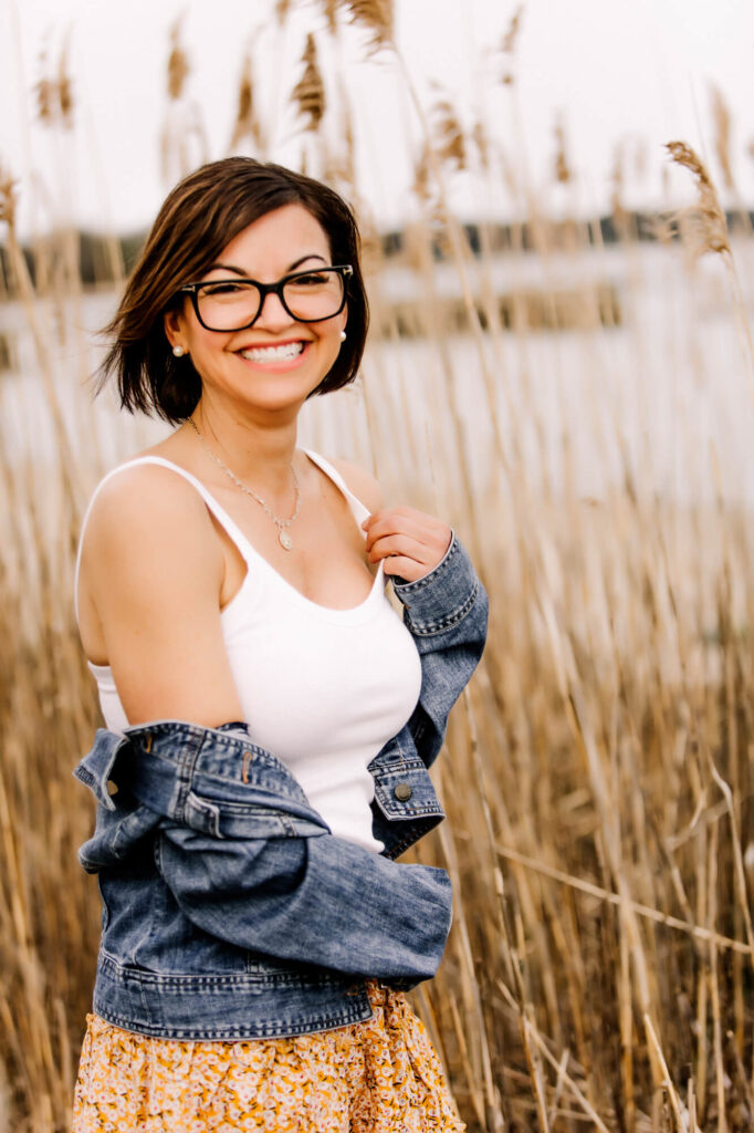 Woman smiling naturally by the ocean, South Shore MA dating profile portrait